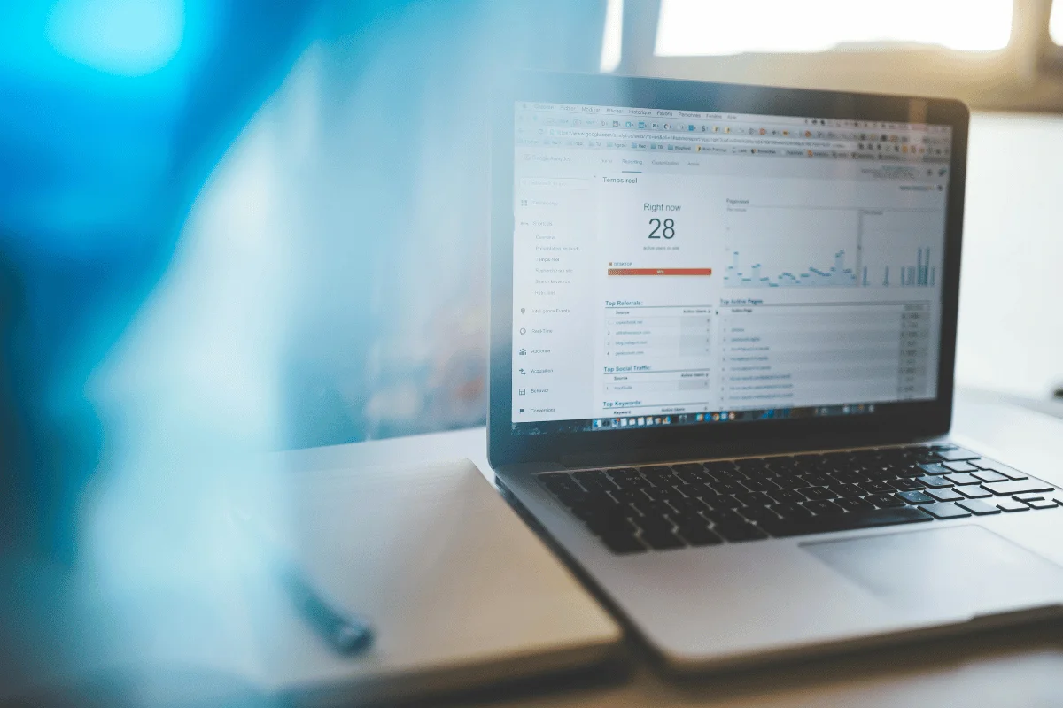 Laptop displaying Google Analytics real-time traffic dashboard on a desk.