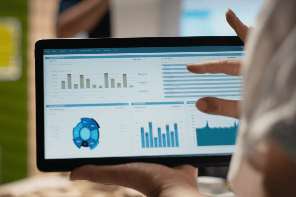 Hands pointing at tablet displaying financial analytics, illustrating data-driven decision making.