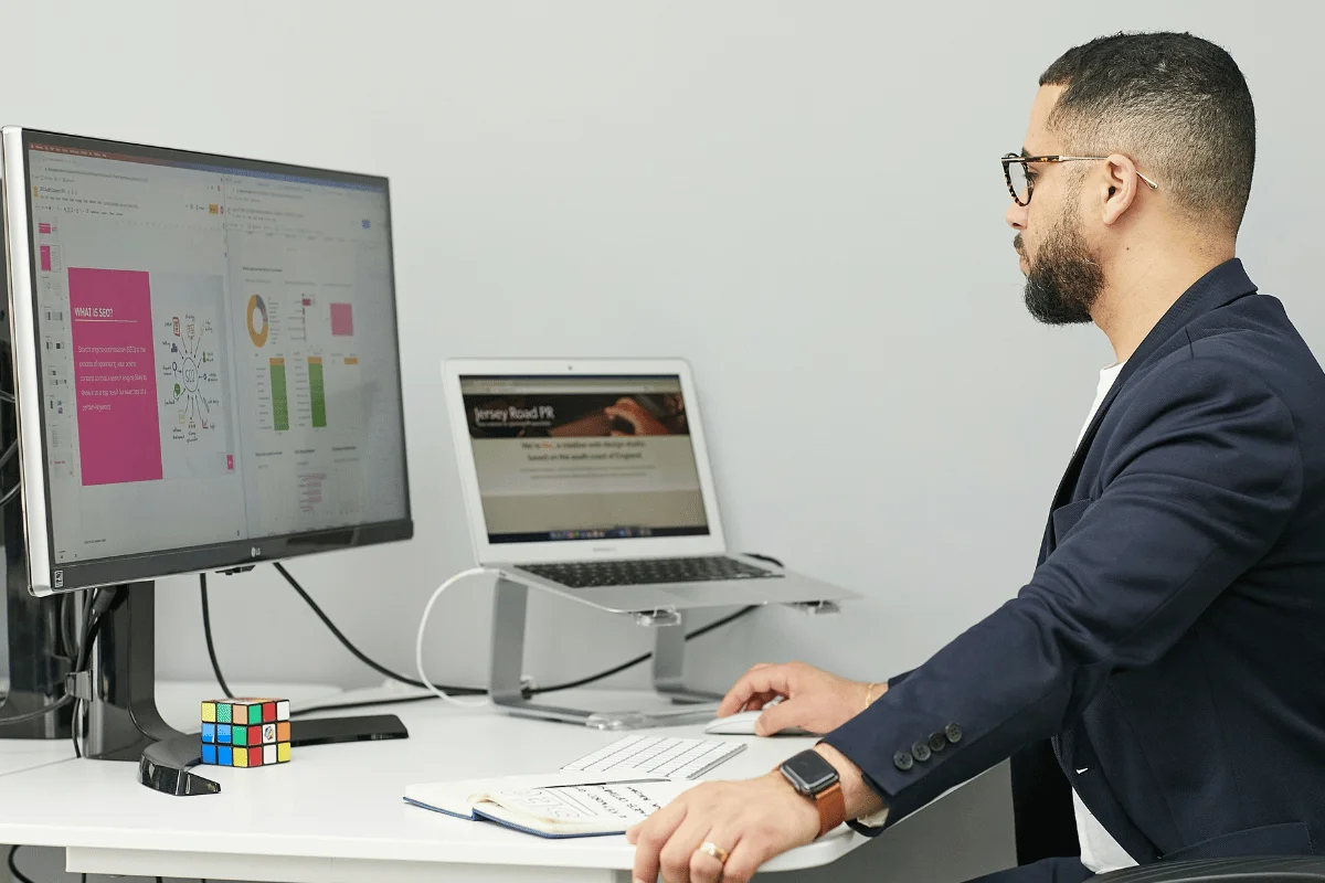 Business professional analyzing data on a large monitor at an office desk